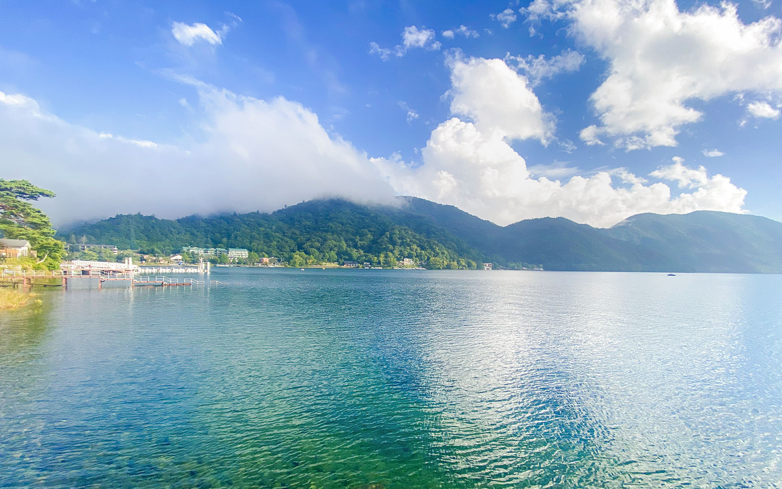 Lake Chūzenji in Nikko with surrounding mountains and clear blue water.