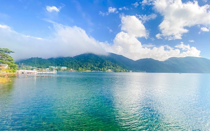 Lake Chūzenji in Nikko with surrounding mountains and clear blue water.