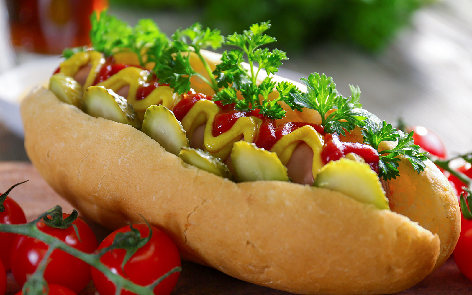 Hot dog with mustard, ketchup, pickles, and parsley