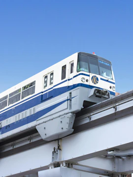 Fukuoka subway train on elevated track against clear sky.