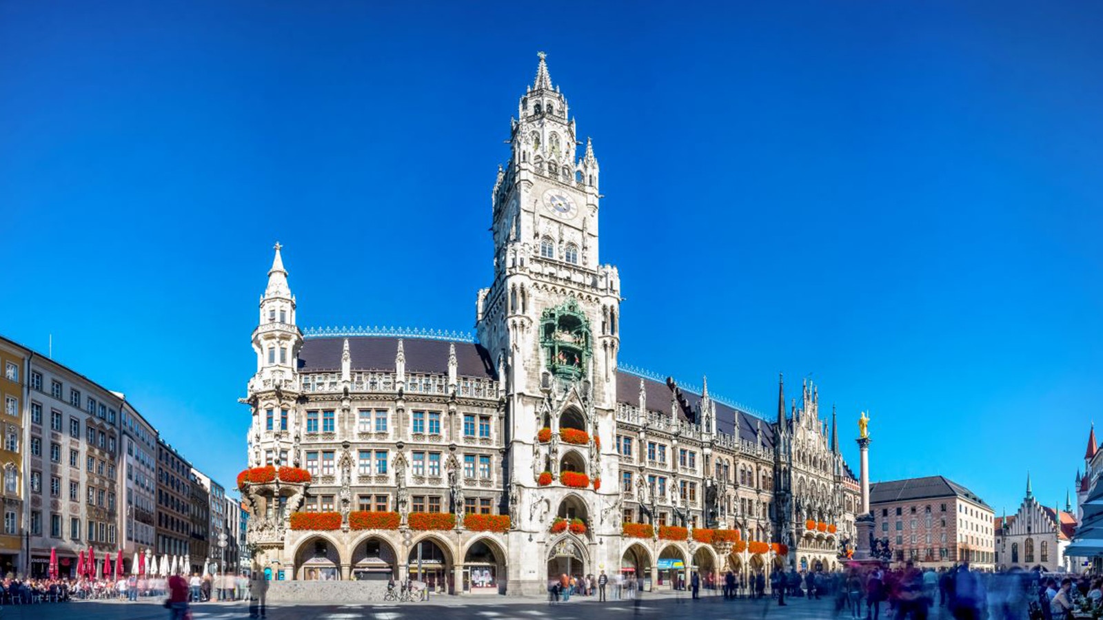 Open-top sightseeing bus in Munich near historic buildings.