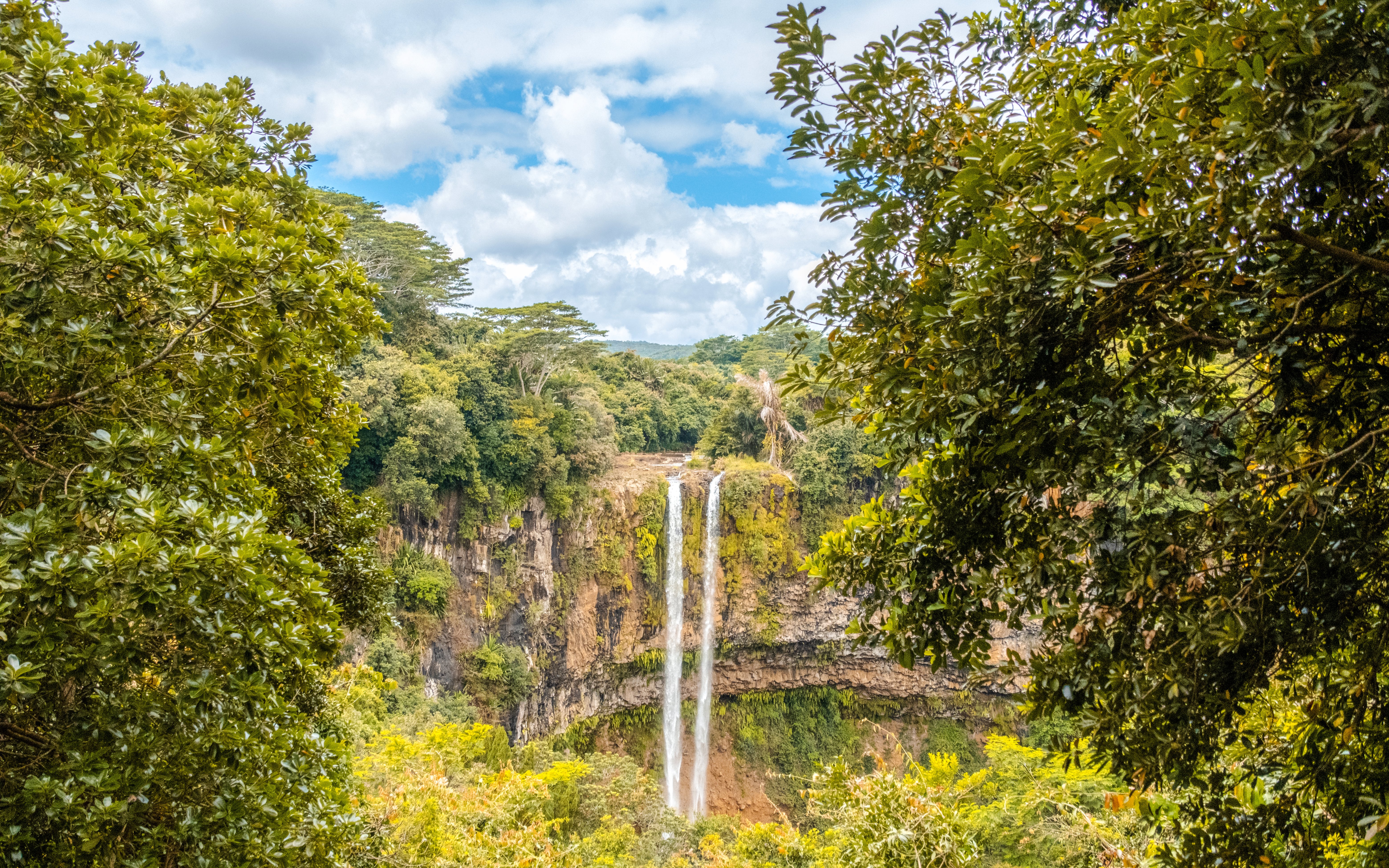 Chamarel waterfall in Mauritius surrounded by lush greenery from a viewpoint.