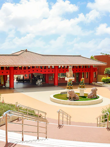 Okinawa World entrance with traditional red pillars and lion statues.