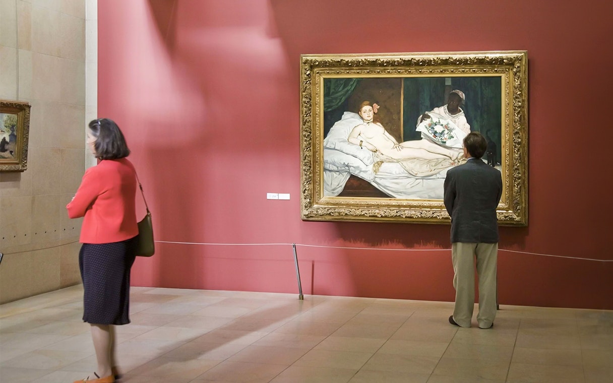 Visitors viewing Manet's "Olympia" painting at Musée d’Orsay, Paris.