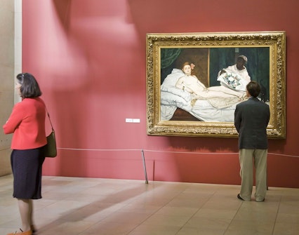 Visitors viewing Manet's "Olympia" painting at Musée d’Orsay, Paris.