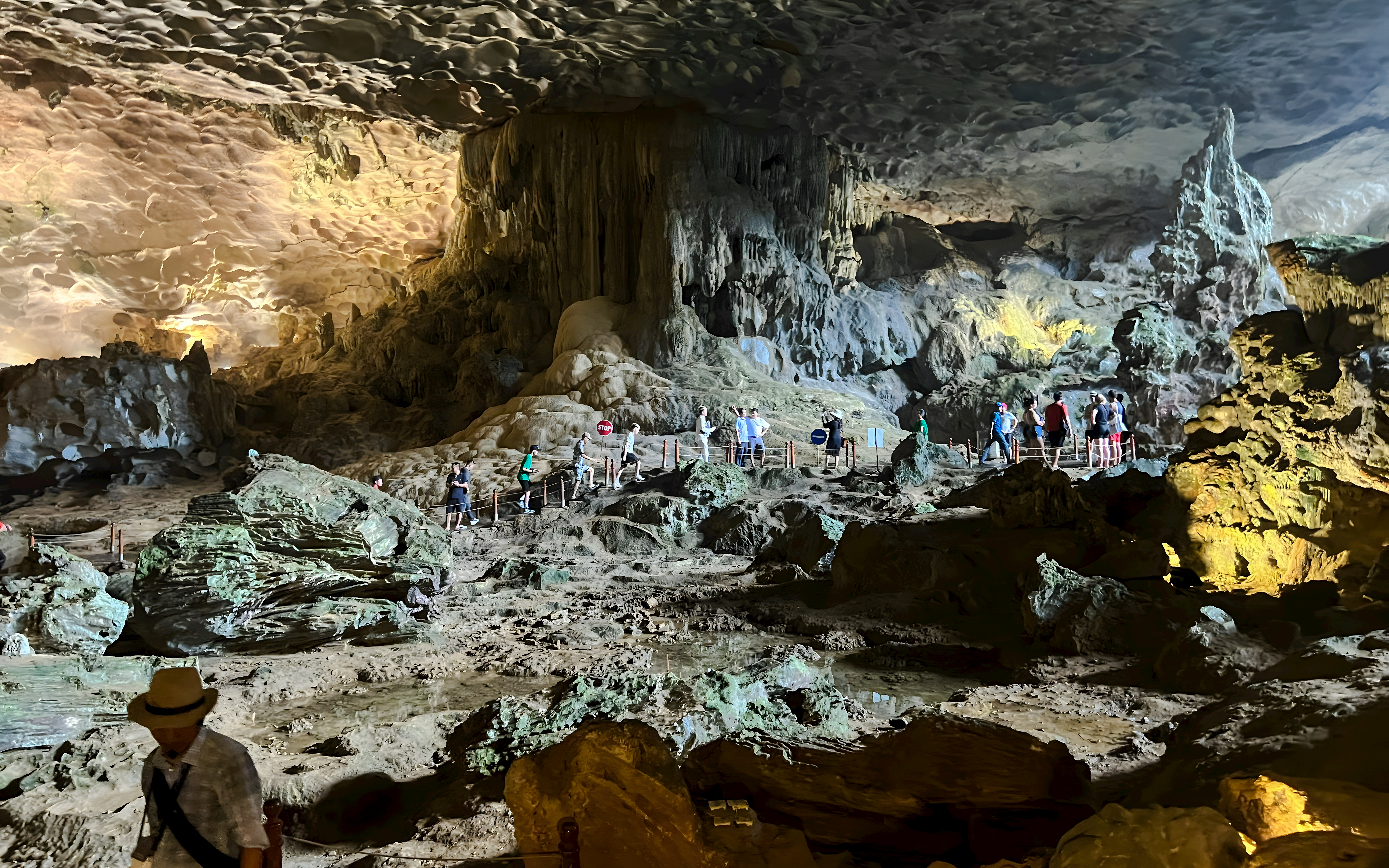 Visitors exploring Bo Hon Cave, Ha Long Bay, observing stalactites and unique rock formations.