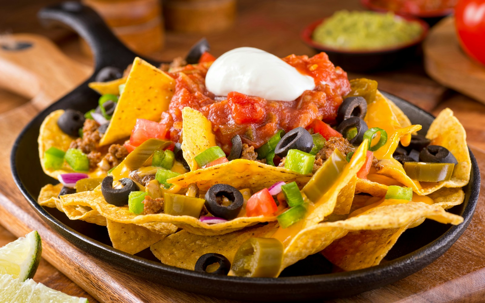 Nachos Supreme bowl with jalapeno, olives, salsa sauce, cheese dip and nachos