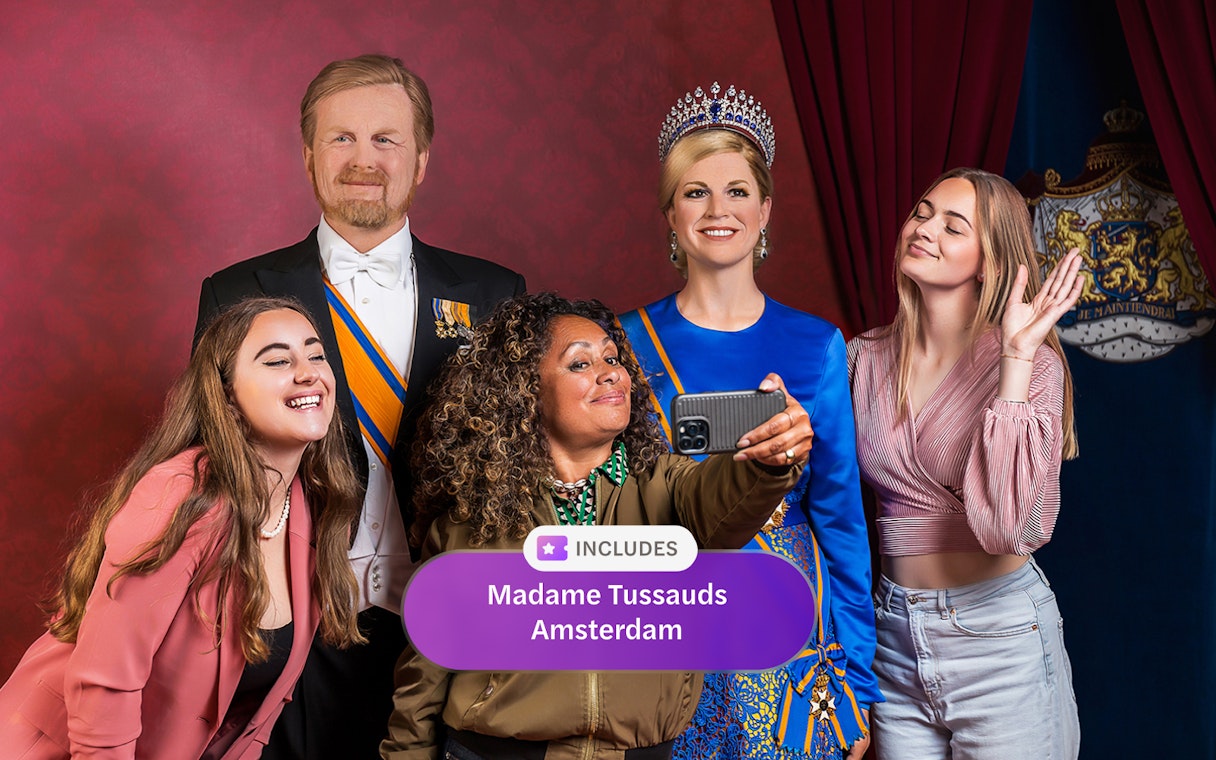 Visitors taking a selfie with wax figures at Madame Tussauds Amsterdam.