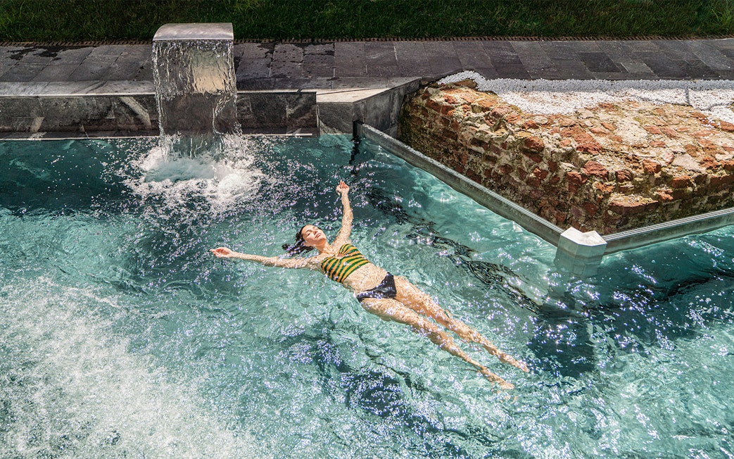 Visitor relaxing in the pool at QC Terme Milano Resort & Spa.