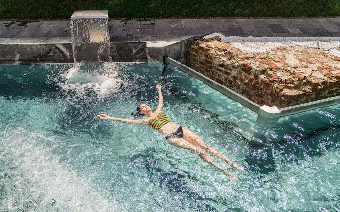 Visitor relaxing in the pool at QC Terme Milano Resort & Spa.