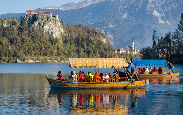 Guided boat tour on Lake Bled with Bled Castle in the background, part of a small group tour from Zagreb.