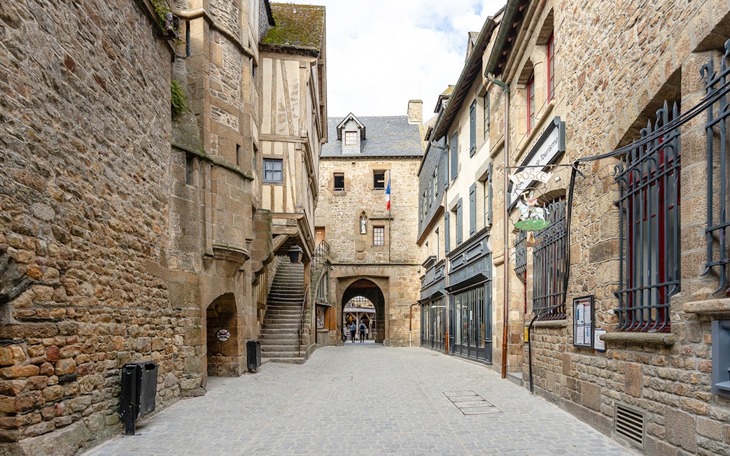 Mont Saint Michel narrow cobblestone street with historic stone buildings.