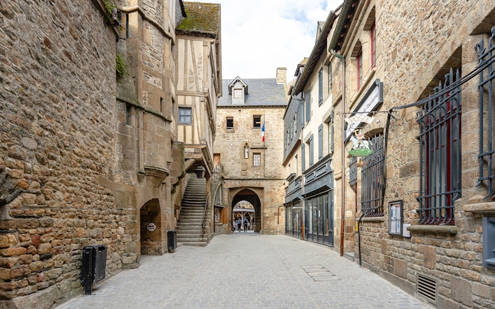 Mont Saint Michel narrow cobblestone street with historic stone buildings.