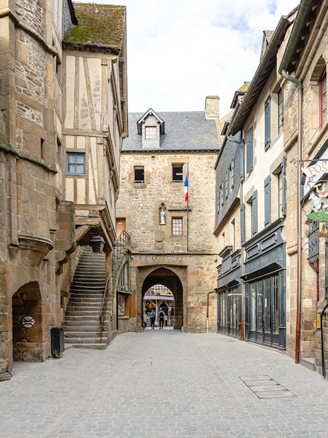 Mont Saint Michel narrow cobblestone street with historic stone buildings.