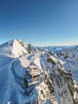 Mount Titlis summit view over Engelberg, Swiss Alps, with snowy peaks and observation deck.