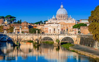 St. Peter's Basilica and Sant'Angelo Bridge over the Tiber River in Rome.
