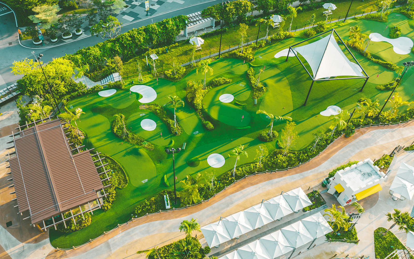 Aerial view of a mini-golf course with green putting areas and sand traps, part of Combo: HyperDrive and UltraGolf.