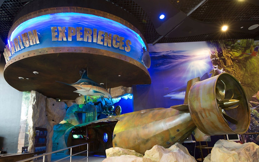 Dubai Aquarium entrance with marine life displays and submarine propeller exhibit.