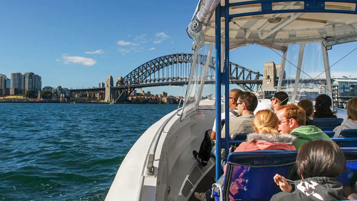 Group touring the Sydney harbour with the Harbour Bridge in the background