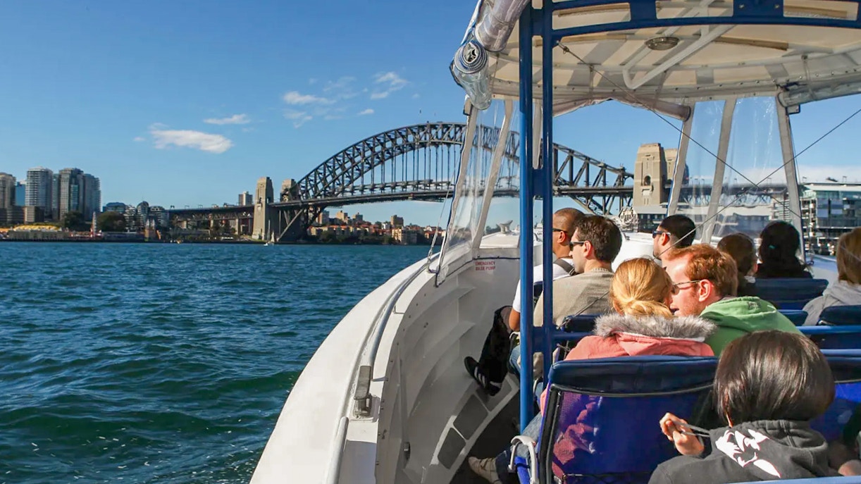 Group touring the Sydney harbour with the Harbour Bridge in the background