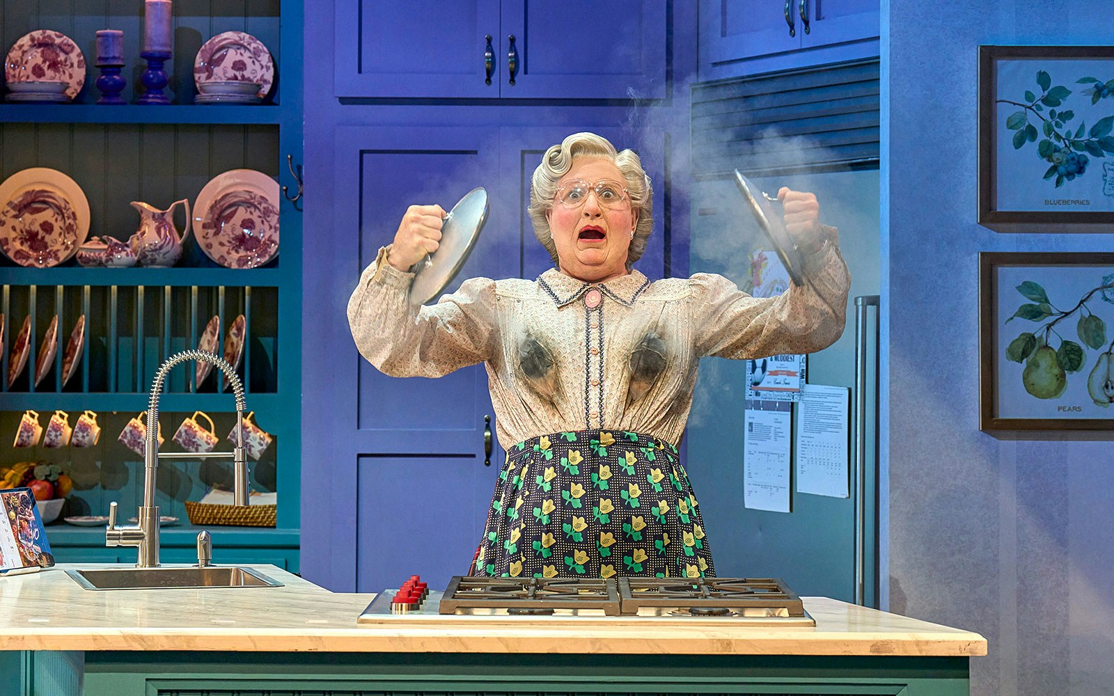 Person in a kitchen with smoke rising, holding pot lids, related to Mrs. Doubtfire.