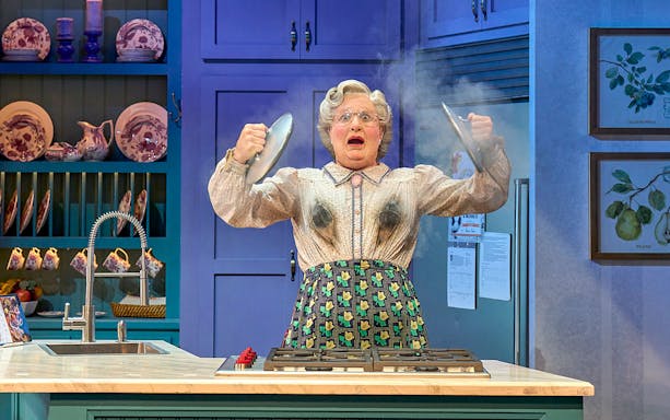 Person in a kitchen with smoke rising, holding pot lids, related to Mrs. Doubtfire.