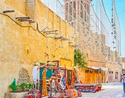 Al Fahidi Historical Neighbourhood market with traditional textiles and wind towers.