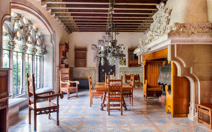 Casa Amatller dining room with ornate wooden furniture and stained glass windows.