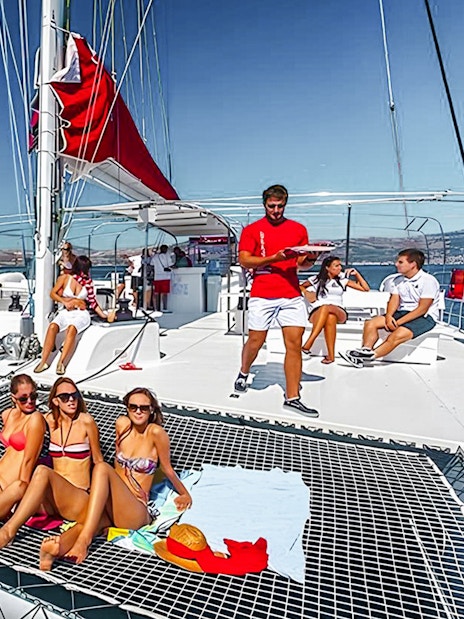 Guests relaxing on a catamaran cruise with barbeque in Santorini.