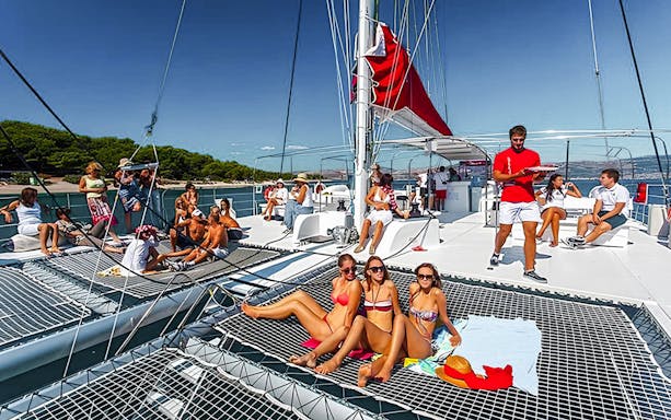 Guests relaxing on a catamaran cruise with barbeque in Santorini.