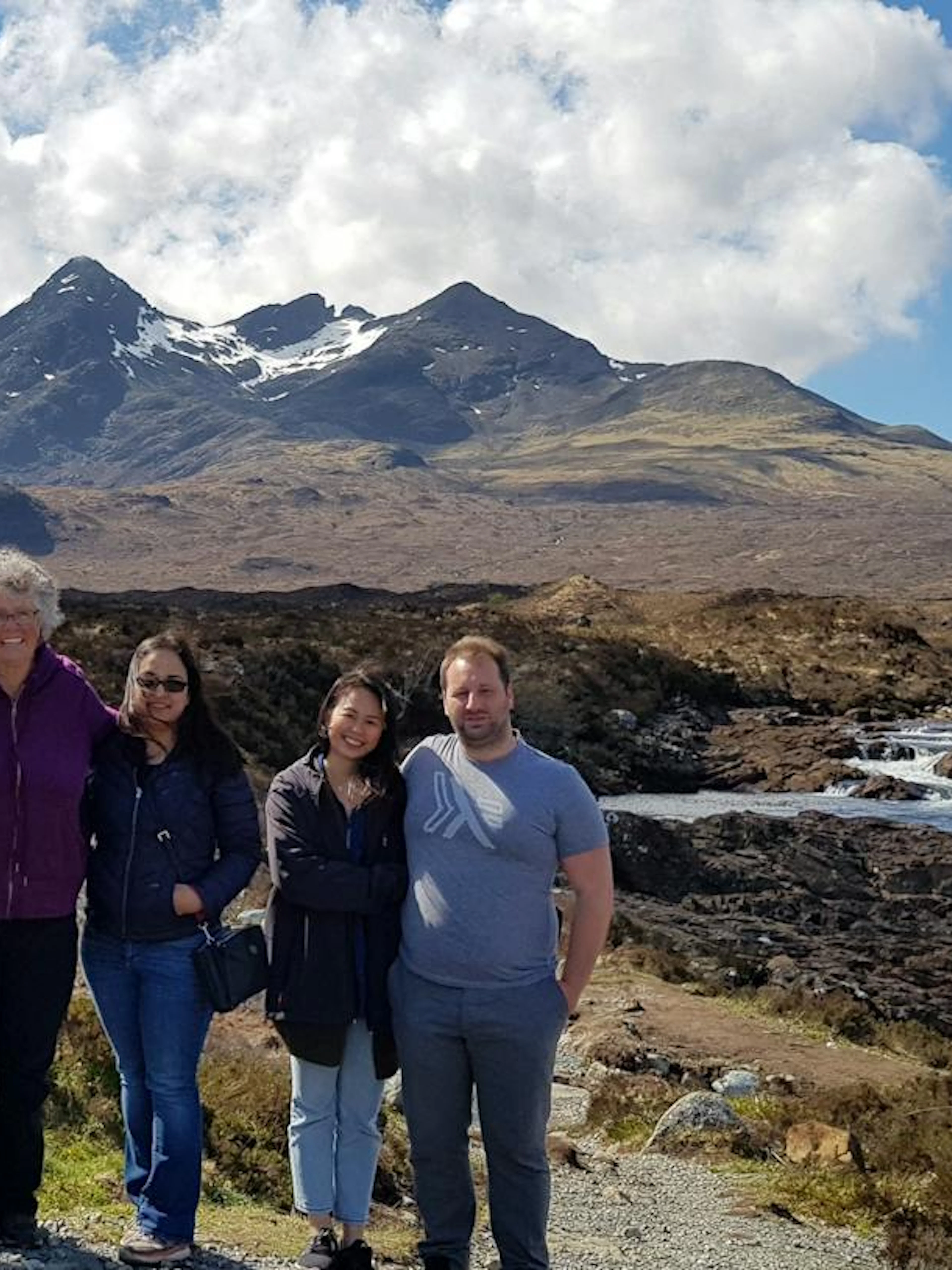 Group of tourists on Isle of Skye day trip with mountains in background, Inverness.
