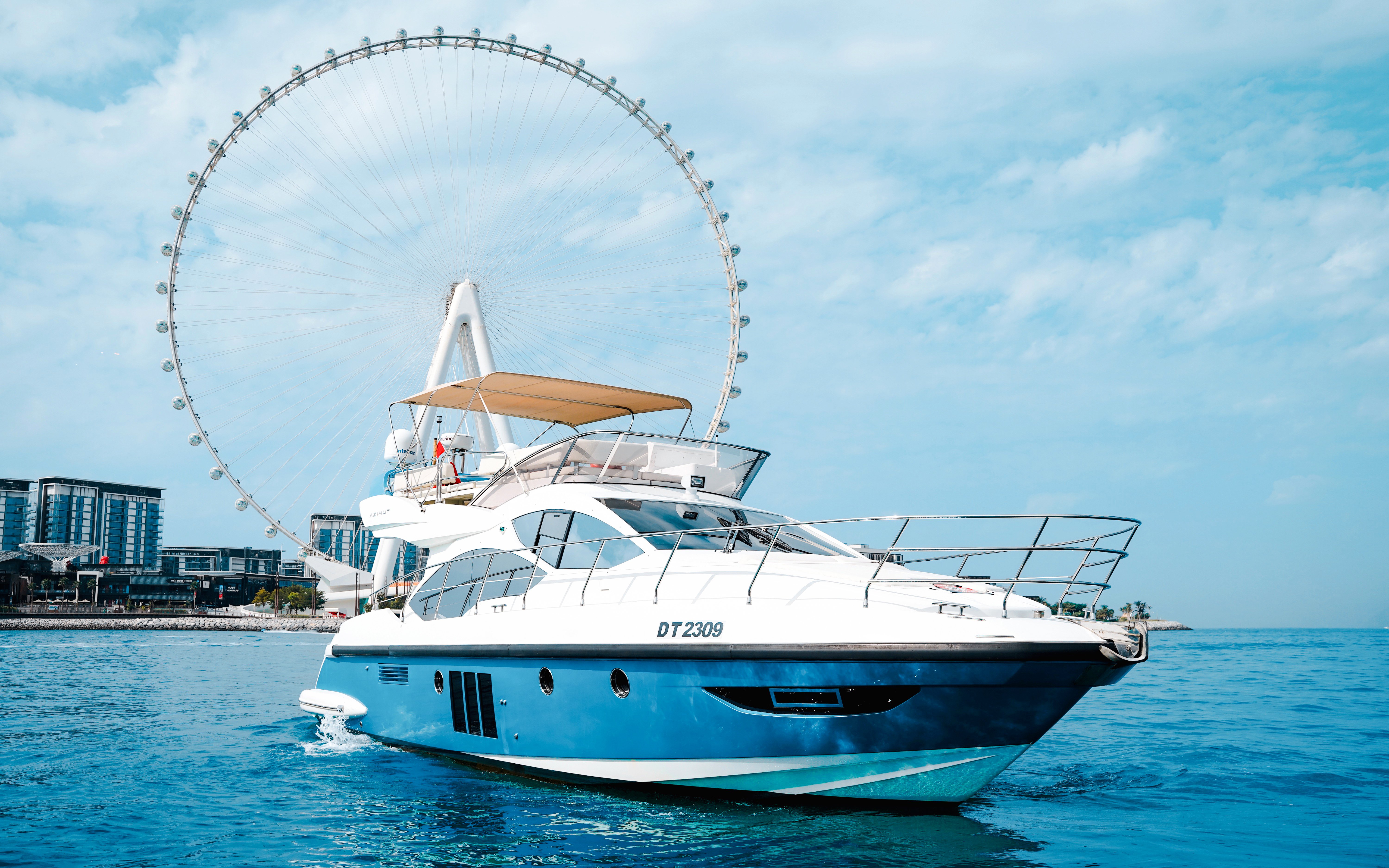 Private luxury yacht sailing near Ain Dubai Ferris wheel.