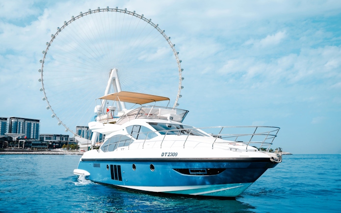 Private luxury yacht sailing near Ain Dubai Ferris wheel.