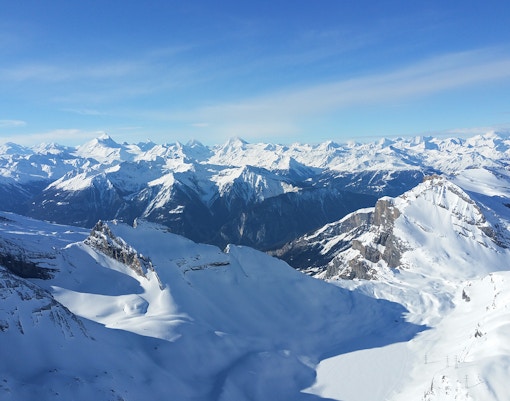Snow-covered mountains in Switzerland under a clear blue sky.