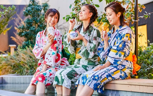 Tourists in yukatas enjoying snacks at Solaniwa Onsen.