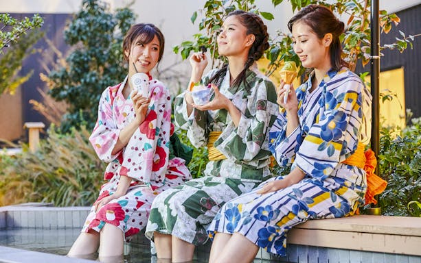 Tourists in yukatas enjoying snacks at Solaniwa Onsen.