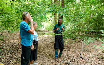 Guide explaining flora to tourists in Kaya Kinondo Forest, Diani Beach.