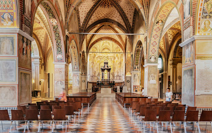 Interior of Lugano Cathedral of Saint Lawrence with ornate arches and altar.