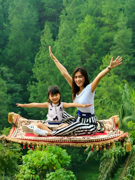 Magic carpet ride experience at Dago Dreampark, Jakarta, Indonesia, with lush forest backdrop.