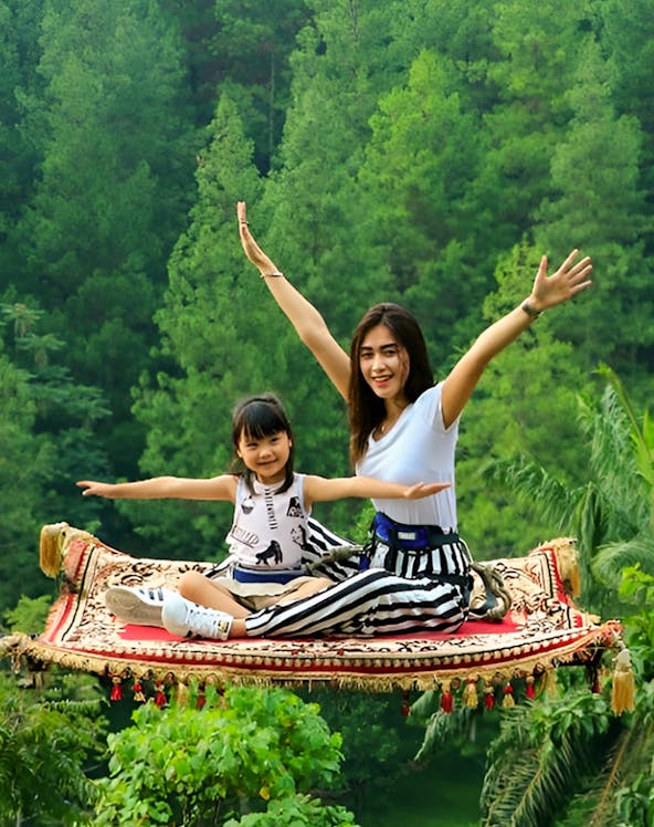 Magic carpet ride experience at Dago Dreampark, Jakarta, Indonesia, with lush forest backdrop.