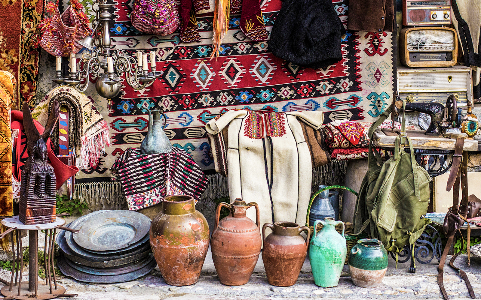 Kruja flea market with traditional Albanian crafts, pottery, and textiles displayed.