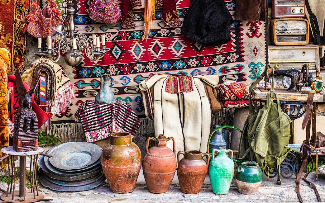Kruja flea market with traditional Albanian crafts, pottery, and textiles displayed.