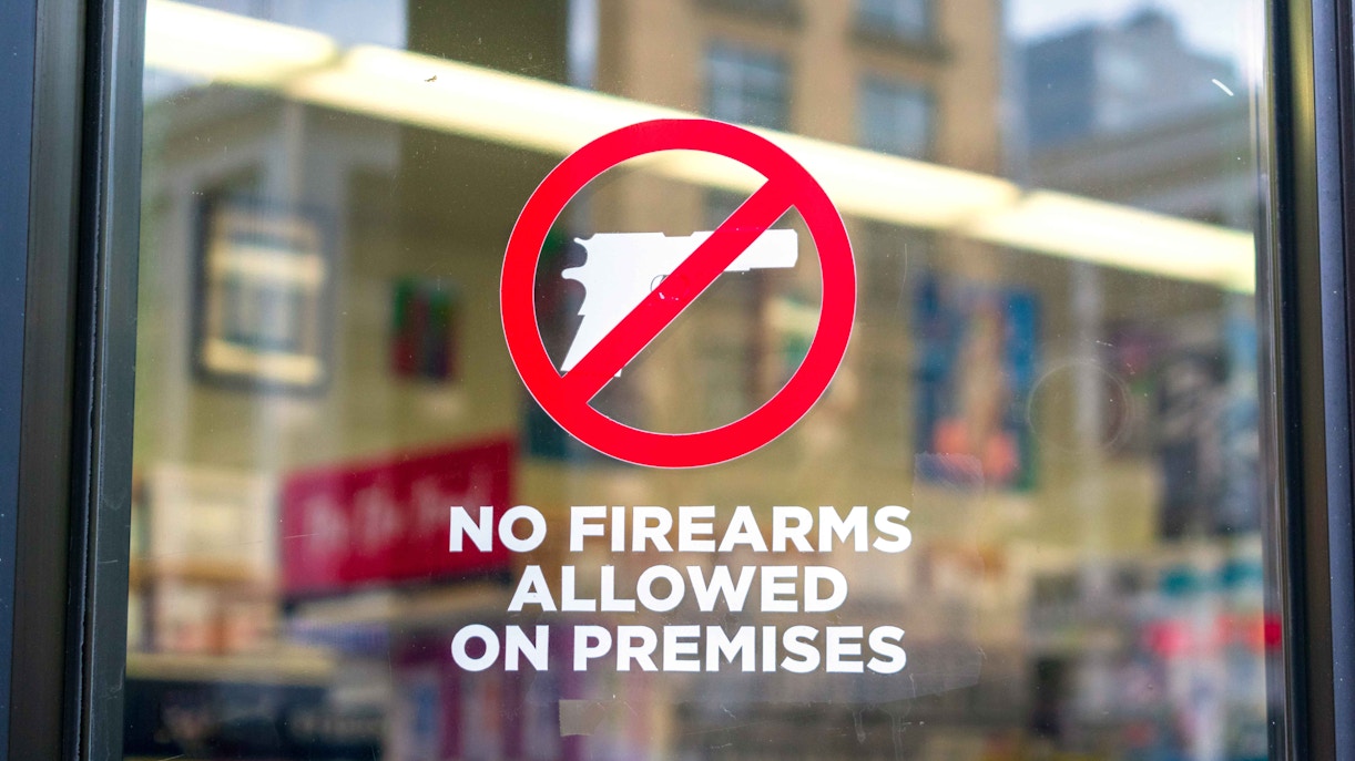 No firearms allowed sign on a store window.