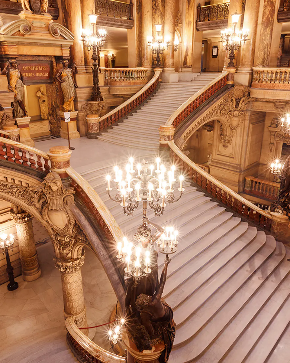 Opera Garnier grand staircase with chandeliers and detailed architecture in Paris.