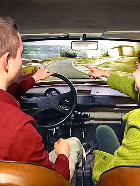 Visitors in a simulated car experience at DDR Museum Berlin.