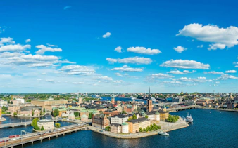 Stockholm cityscape with historic buildings and waterways under a blue sky.