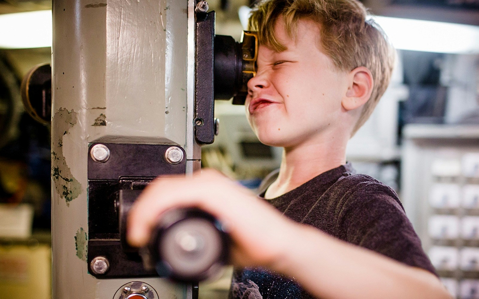 Child looking through a periscope at a San Diego museum exhibit.