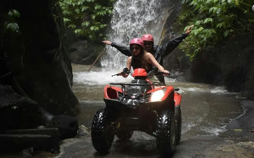 ATV ride through waterfall tunnel on Kuber tour, Bali.