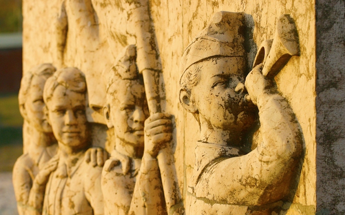 Stone relief of soldiers with a bugler at Memento Park, Budapest.