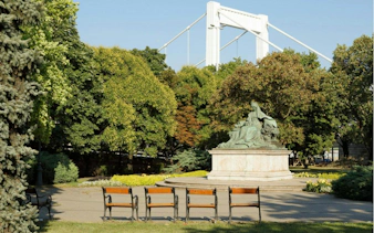 Statue in a Budapest park with Elizabeth Bridge in the background, part of the city exploration game.